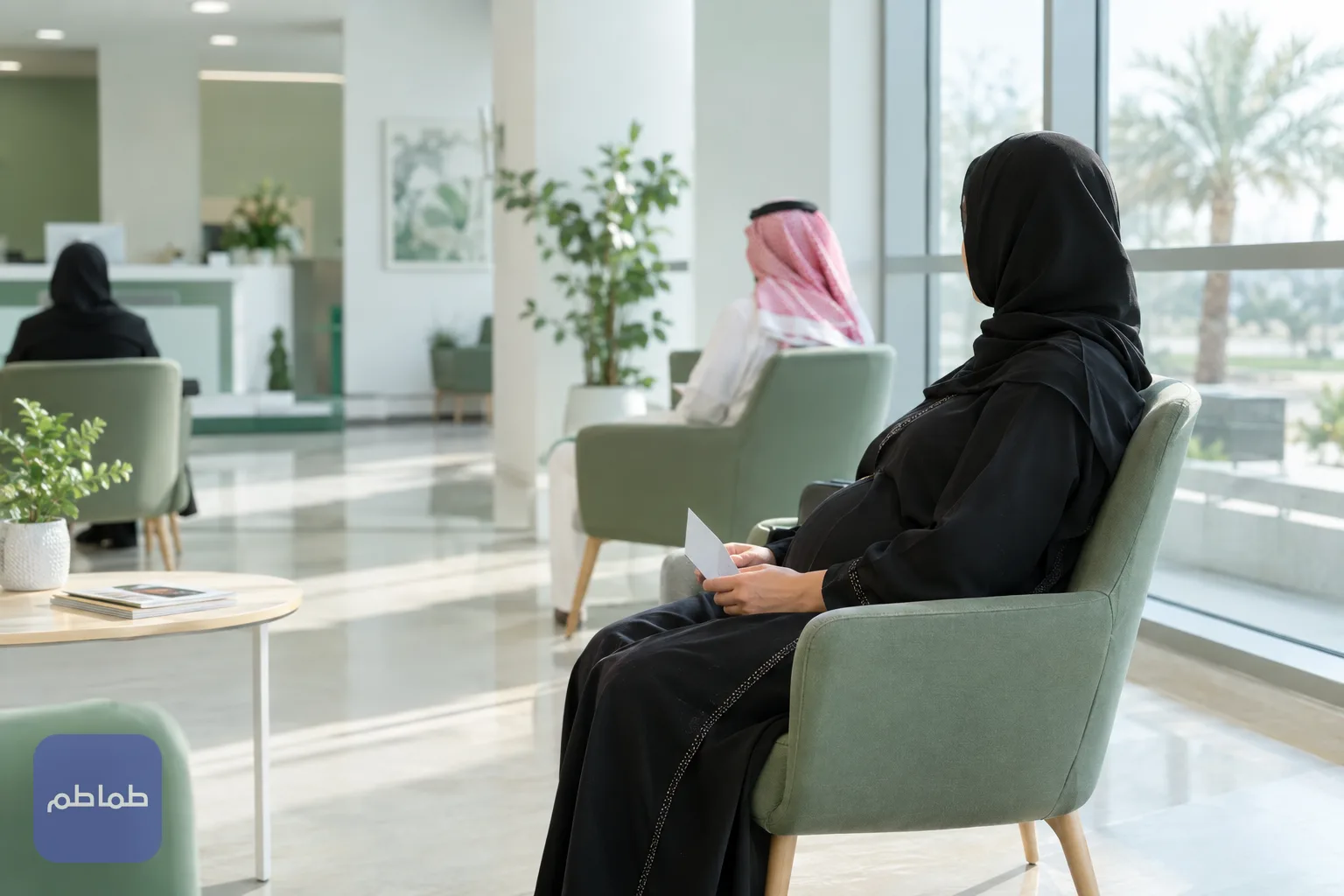 امرأة حامل تنتظر في مركز رعاية أولية هادئ وبيدها بطاقة موعد